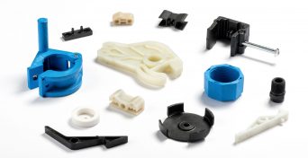 Many different injection plastic parts of white, blue and black colour spread on white background